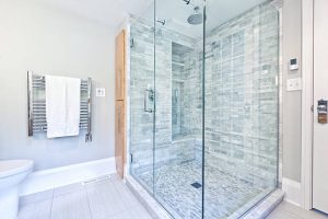Contemporary interior bathroom design with glass enclosed shower still with Heated towel rack hanger.