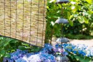 Rain chains and bamboo blind hanging before a Japanese garden