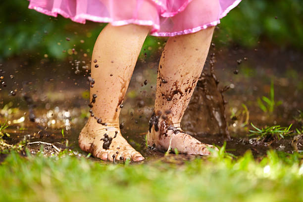 little girl splashing in the mud garden