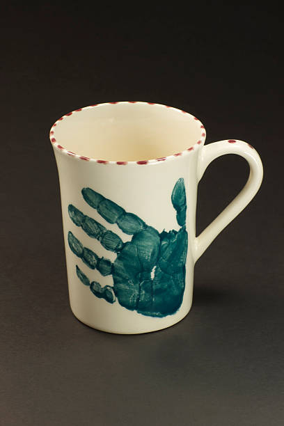  Coloured mug with an imprint of a child's hand on it.