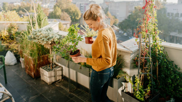 woman taking care of her plants on a rooftop garden
