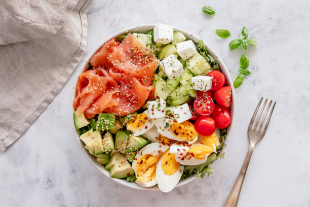 Overhead view of a low carb meal salad made of smoked salmon, hard boiled eggs with some leafy greens