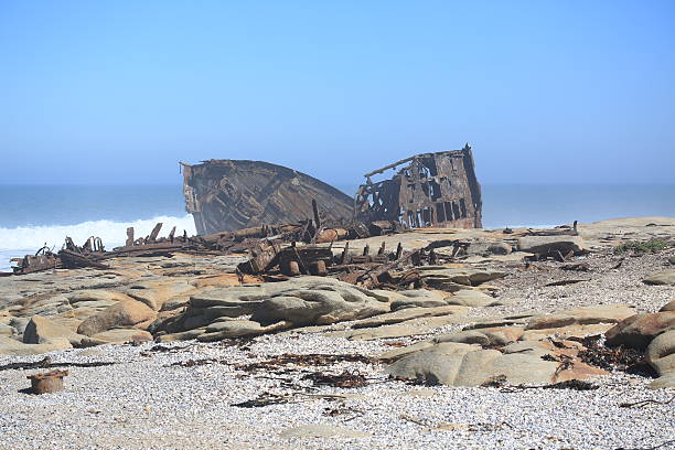 Scattered remains of a ship wreck in the mist on the South African Northern Cape Namaqualand Skeleton Coast