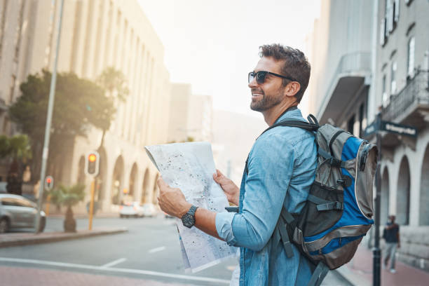 Young man looking at a map while backpacking in a foreign city