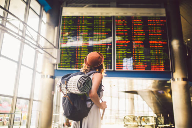 young woman standing with backpacking back in airport 