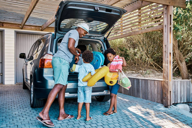 A family packing the car to leave for summer vacation. 