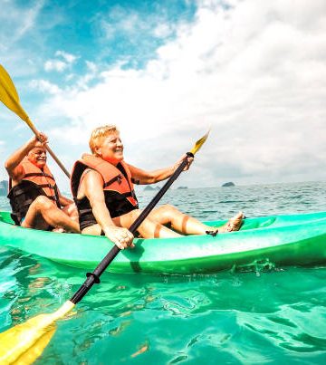 Happy retired couple enjoying travel moment paddling on kayak