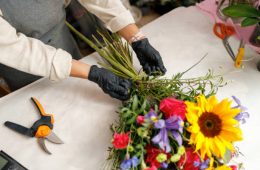 Female decorator creating beautiful bouquet at table. Lifestyle flower shop