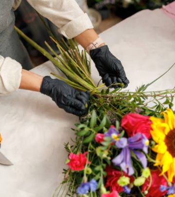 Female decorator creating beautiful bouquet at table. Lifestyle flower shop