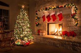 Glowing Christmas fireplace and living room, with tree, and stockings hanging from mantel by fireplace.Waiting for Santa.