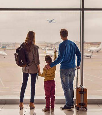 Such large aircraft. Back view shot of young family with luggage standing near window in airport before boarding