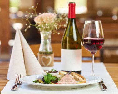 Boar pate with vegetables and plum jam and red wine in a restaurant