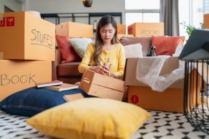 happiness young adult asian female Woman packing things into boxes prepare moving from old place to new home with cheerful and happiness,home moving house booming ideas concept