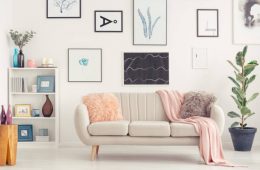 Elegant sofa, white shelf with decorations and posters on the wall in a living room interior