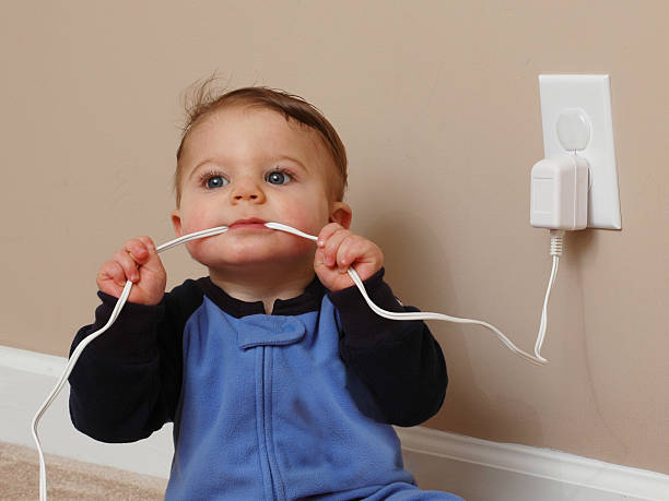 baby boy chews on an electrical cord.